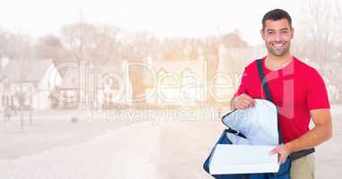 Delivery man with bag and pizza against blurry housing estate with flare