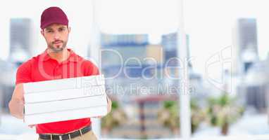 Delivery man with pizzas against blurry buildings