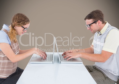 Nerd couple at laptops against brown background