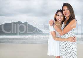 Best friends hugging against blurry beach