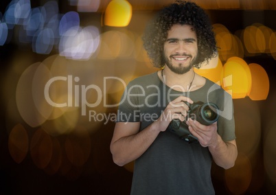 happy photographer with camera on hands at night. Blue and yellow blurred lights behind and overlap