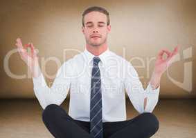 Business man meditating against brown wall