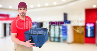 Delivery man against blurry shopping centre