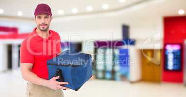 Delivery man against blurry shopping centre