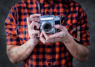 Millennial man mid section with camera against grey background with grunge overlay