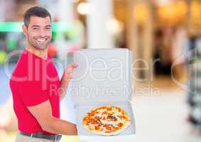 Delivery man with pizza against blurry shopping centre