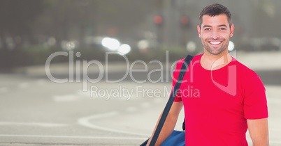 Delivery man with blue bag against blurry street