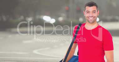 Delivery man with blue bag against blurry street