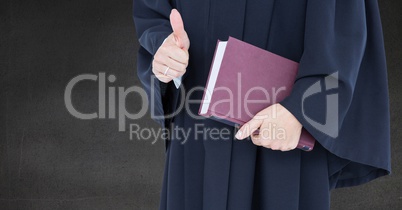 Female judge mid section with book and thumbs up against grey wall