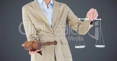 Female judge mid section with scales and gavel against grey background