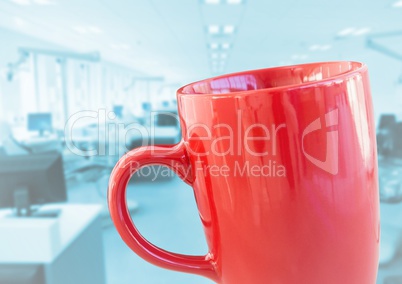 Red coffee cup against blurry blue office
