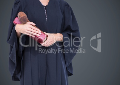 Female judge mid section with book and gavel against grey background