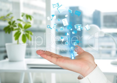 hand with application blue icons coming up form it. Blurred office background
