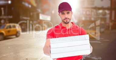 Delivery man with pizza boxes against blurry street with flare