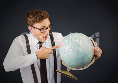 Nerd man pointing at globe against navy chalkboard