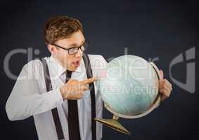 Nerd man pointing at globe against navy chalkboard
