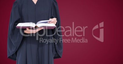 Female judge mid section with open book against maroon background