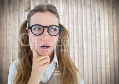 Close up of nerd woman thinking against blurry wood panel