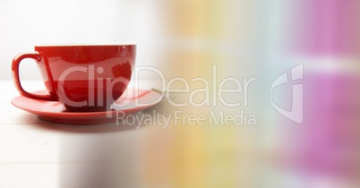 Red coffee cup with beans and blurry rainbow transition
