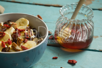 Fruit cereal and honey on a wooden table