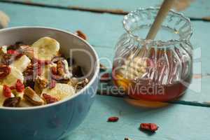 Fruit cereal and honey on a wooden table