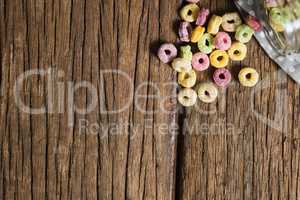 Scattered cereal rings from jar on wooden table