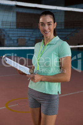 Portrait of female volleyball coach with clipboard