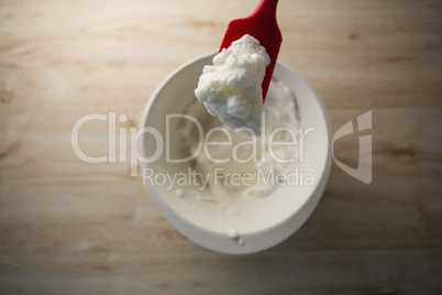 Directly abvoe shot of red spatula with whipped cream