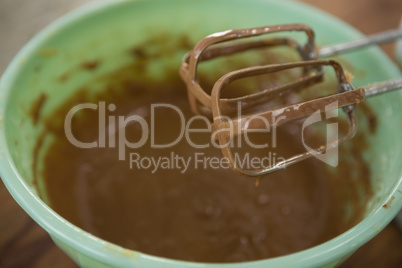 Close up of electric mixer by bowl with chocolate batter