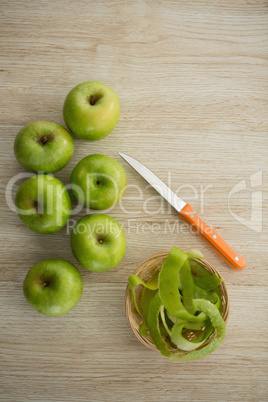 Overhead view of granny smith apples by peel and kitchen knife