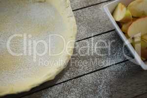 High angle view of pastry dough and apple slices in container
