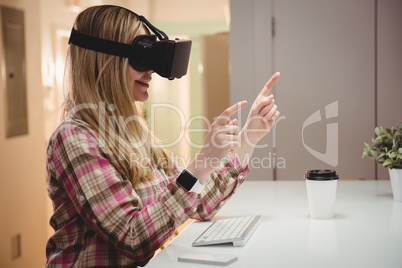 Female executive using virtual reality headset in office