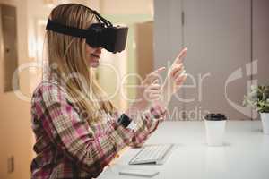 Female executive using virtual reality headset in office