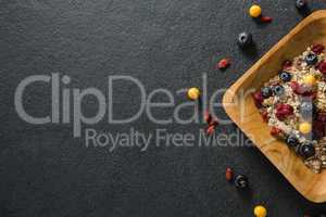 Plate of breakfast cereal with fruits on black background