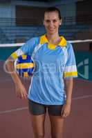 Portrait of smiling woman holding volleyball