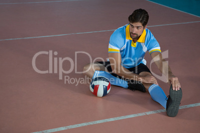 Volleyball player stretching at court