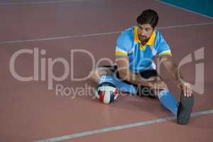 Volleyball player stretching at court