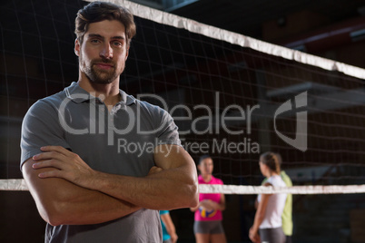Portrait of confident volleyball player with teammates in background