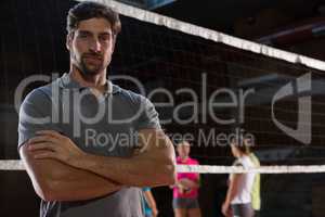 Portrait of confident volleyball player with teammates in background