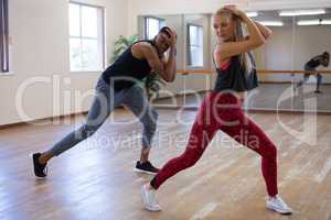 Full length of dancers rehearsing against mirror on floor