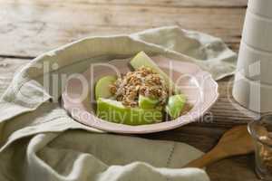 Plate of breakfast cereals with fruits on wooden table
