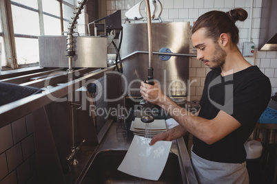 Waiter washing plates in cafe