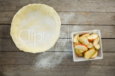 Overhead view of pastry dough and apple slices in container