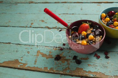 Bowls of breakfast cereals and fruits with spoon