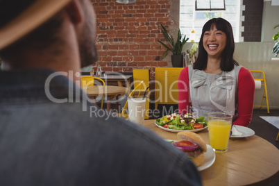 Happy woman looking at man in cafe