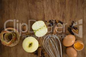 Overhead view of wire whisk with apple and spices