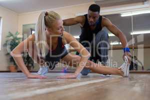 Dancer assisting female friend in stretching on floor