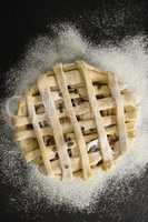 Overhead view of apple pie amidst flour