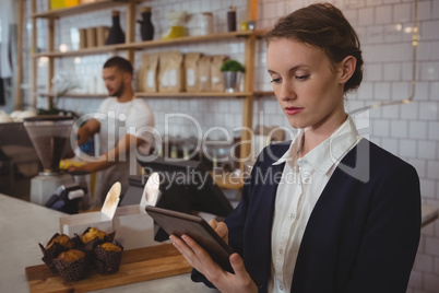 Owner using tablet with waiter working in cafe
