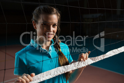 Portrait of volleyball player by net